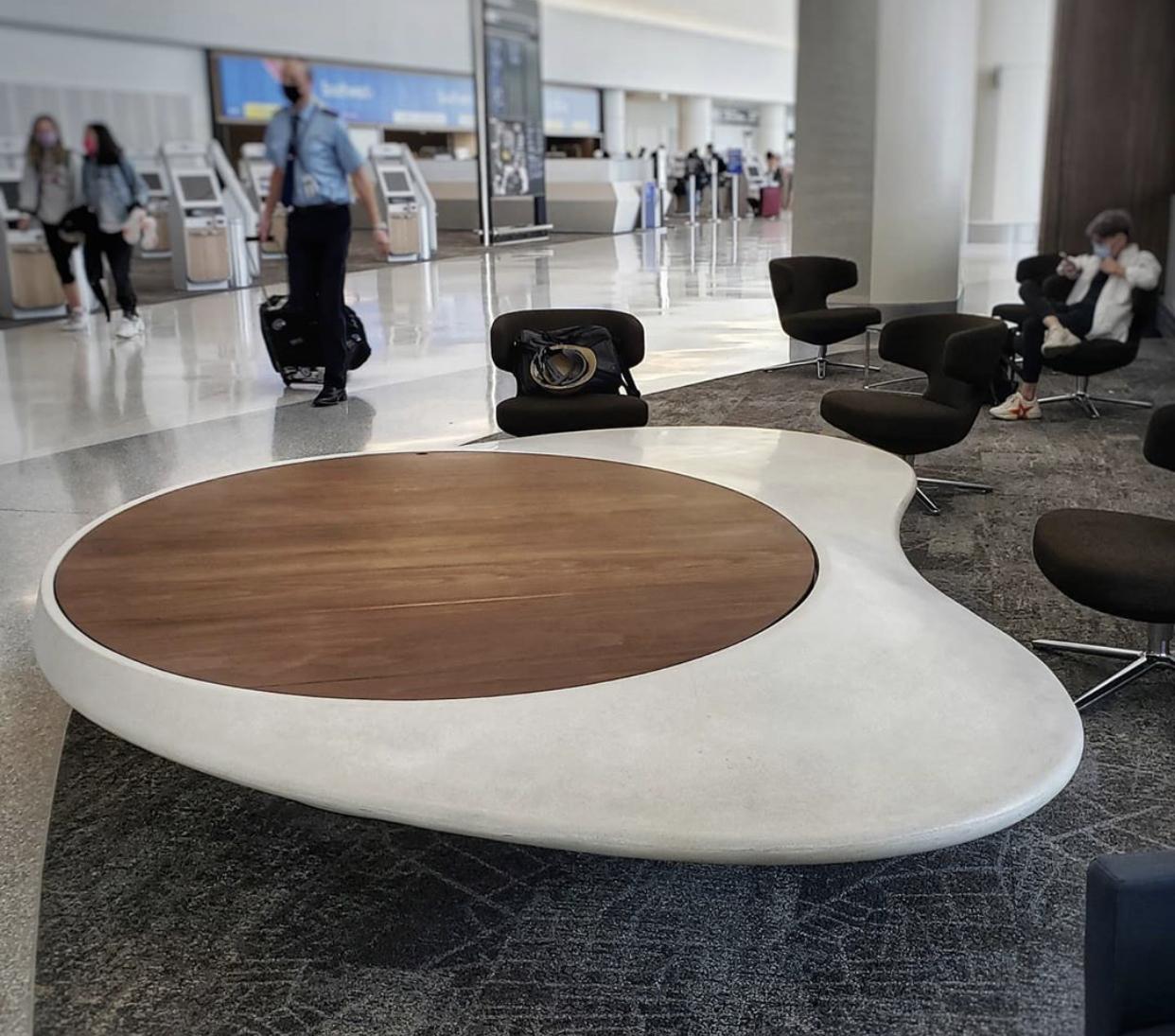 Seating area in black with and wood at the airport. 